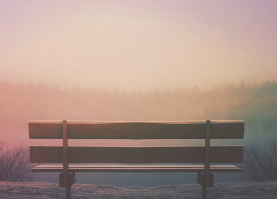 wooden bench facing sunset