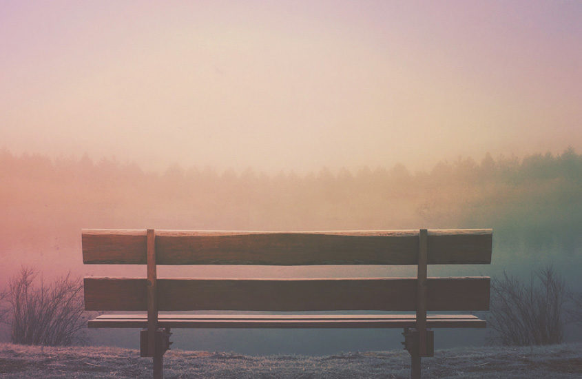 wooden bench facing sunset