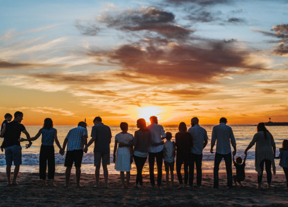 family in silhouette watching a sunset