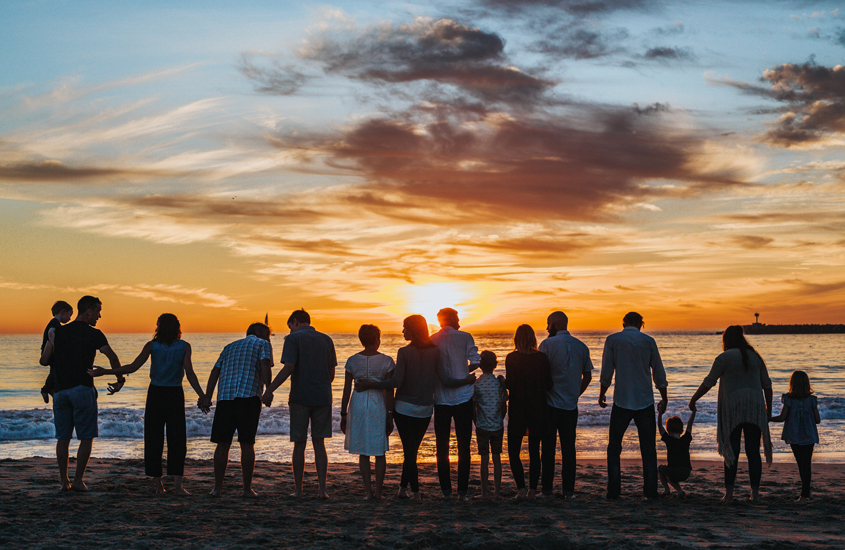 family in silhouette watching a sunset